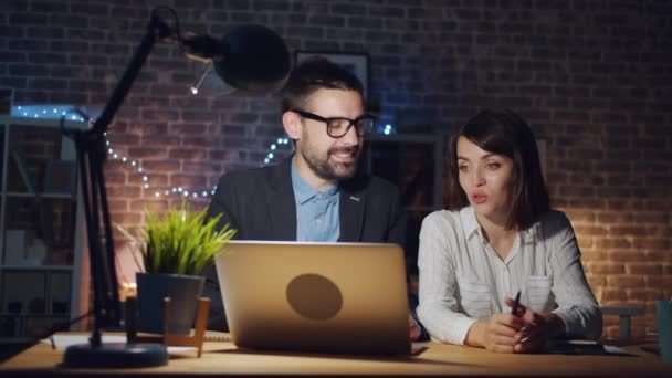 Portré férfi és nő kollégák dolgozik laptop az irodában beszél — Stock videók
