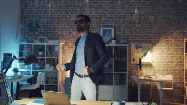 Zeitlupe von gut gelaunten Geschäftsmann, der nachts im Büroraum tanzt und Spaß hat — Stockvideo