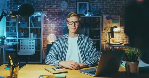 Pauză de timp de tip blond atractiv uitându-se la cameră în birou noaptea târziu — Videoclip de stoc