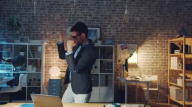 Ofiste dans eden komik gözlükler takan genç adamın yavaş çekimleri.