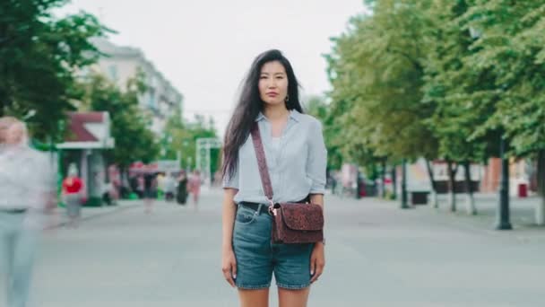 Zoom-out retrato de mujer asiática de pie en la calle peatonal en el día de verano — Vídeos de Stock