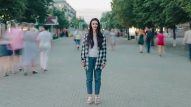 Şehir caddesinde kameraya bakıp gülümseyen bir kız vardı.
