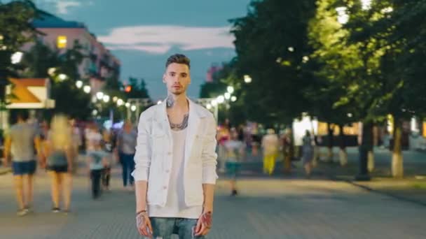 Čas vypršení atraktivní mužské hipster stojící v městské ulici ve večerních hodinách — Stock video