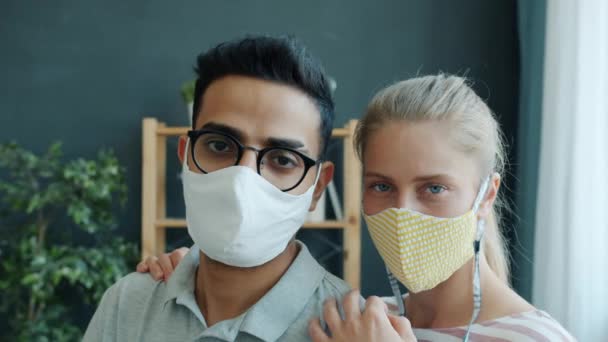 Ritratto al rallentatore dell'uomo mediorientale e della donna caucasica in maschere mediche al chiuso — Video Stock