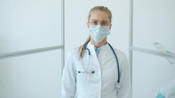 Movimento lento del medico femminile in tuta bianca e maschera facciale su sfondo bianco — Video Stock