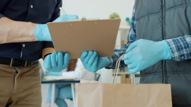 Close-up de empresário recebendo entrega no cargo durante covid 19 pandemia — Vídeo de Stock