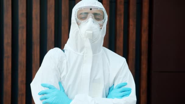 Retrato del hombre en traje de protección médica parado al aire libre con los brazos cruzados — Vídeos de Stock