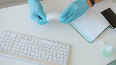 Erkeklerin eldiven giyip, iş yerinde dezenfektanla temizleme cihazlarını yakın plan çekimleri sırasında.