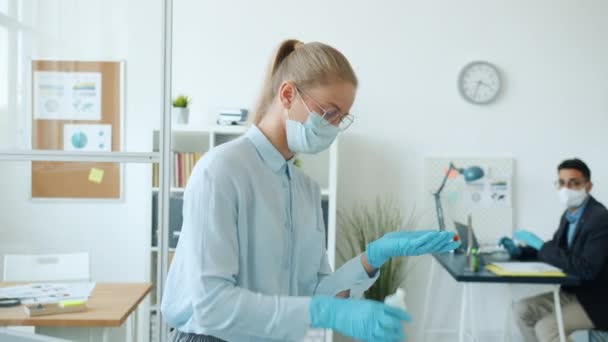 Office employees using hand sanitizer and talking during corona virus pandemic — Stock Video