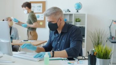 Corona virüsü salgını sırasında ofiste çalışan iş adamlarının sıcaklığını ölçen kadın