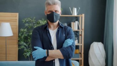 Salgın sırasında evde tekrar kullanılabilir pamuk maskeli bir adamın portresi.