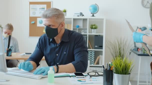 Des employés de bureau testent la température corporelle avec un thermomètre infrarouge pendant une pandémie mondiale — Video