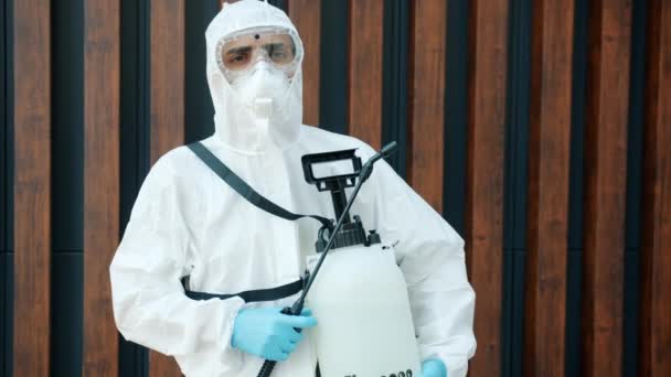Portret bliskowschodniego dezynfektora posiadającego sprzęt dezynfekujący stojący na zewnątrz — Wideo stockowe