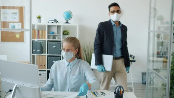 Árabe hombre en máscara y guantes saliendo oficina haciendo high-five con caucásico mujer colega — Vídeos de Stock