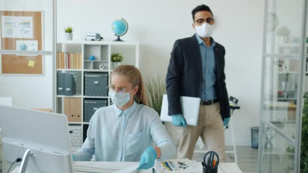 Araber mit Maske und Handschuhen verlässt Büro und macht High-Five mit kaukasischer Kollegin — Stockvideo