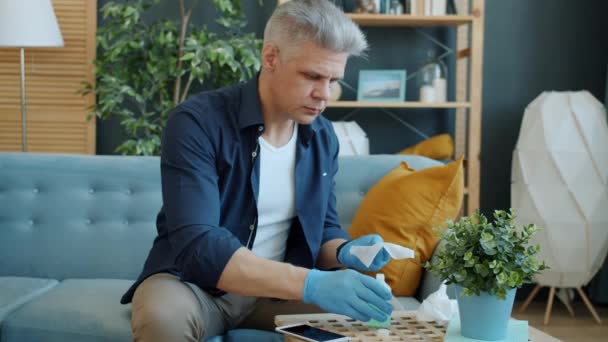 Muž otírání smartphone s rukou dezinfekci zabraňující infekci během pandemie — Stock video