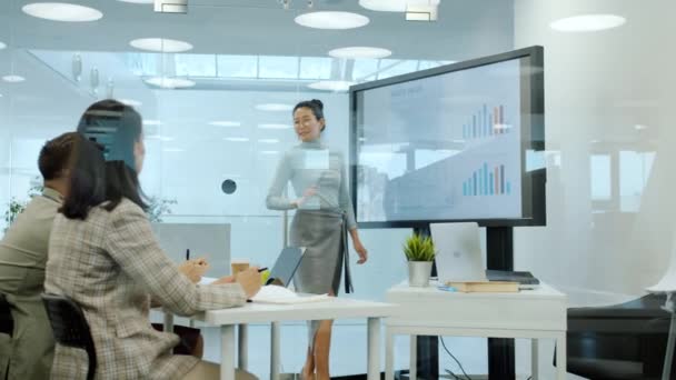 Mulher de negócios asiática falando com grupo de pessoas na sala de reuniões usando quadro branco digital — Vídeo de Stock