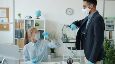 Ofis çalışanları beyaz kız ve Arap adam karantina sırasında dirsek çakıyor.