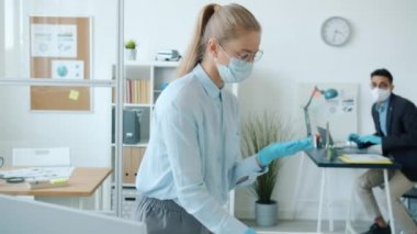 Kadın ve erkeğin el yıkama dezenfektanla ellerini yıkaması ve ofiste konuşması.