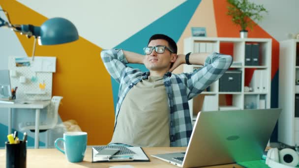 Cinemagraph lus van de jongeman ontspannen in het kantoor terwijl stoom stijgt uit koffiebeker — Stockvideo