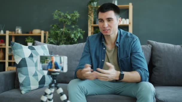 Happy guy vlogger videó tartalmat sugárzó okostelefon kamera otthon — Stock videók