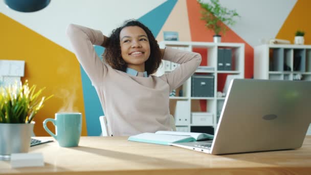 Cinemagraph loop de menina de raça mista relaxando no escritório, enquanto o vapor subindo de xícara de café quente — Vídeo de Stock