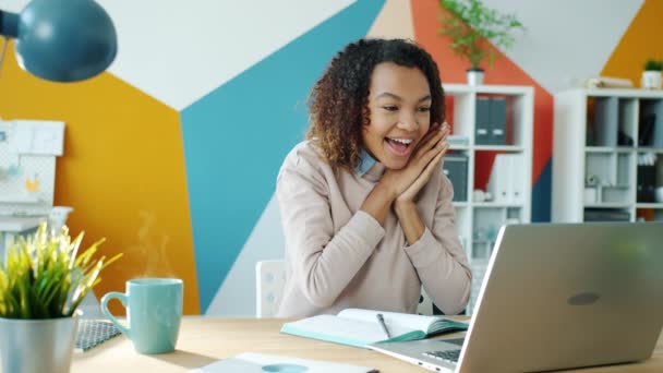 Loop infinito de feliz empresária afro-americana olhando para tela do laptop expressando felicidade — Vídeo de Stock