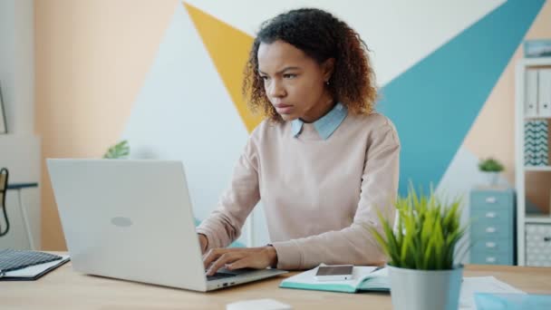 Joven afro-americana chica usando el ordenador portátil en la oficina y luego salir sintiéndose enojado e infeliz — Vídeos de Stock