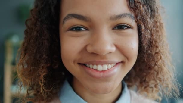Filme lento headshot de atraente adolescente afro-americano sorrindo em casa — Vídeo de Stock