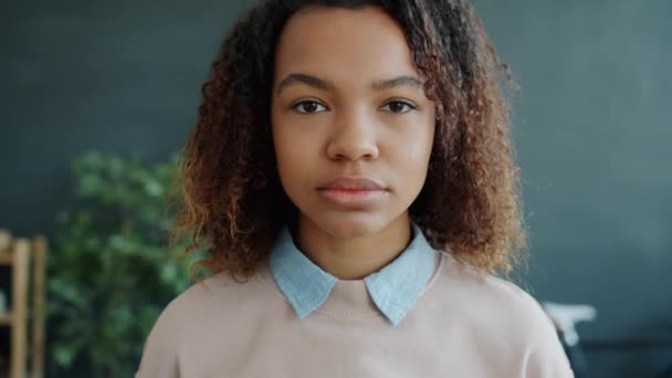 Portret van prachtige gemengde ras meisje met krullend haar op zoek naar camera met serieus gezicht — Stockvideo