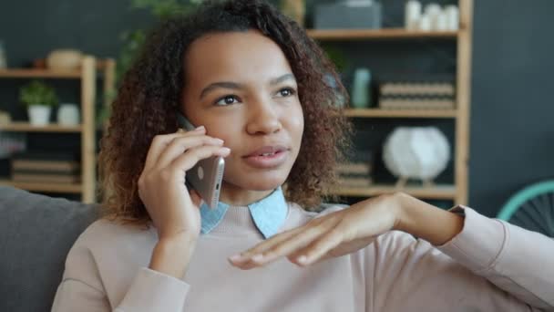 Lambat gerak wanita Afrika Amerika bahagia berbicara di telepon genggam dan tersenyum di rumah — Stok Video