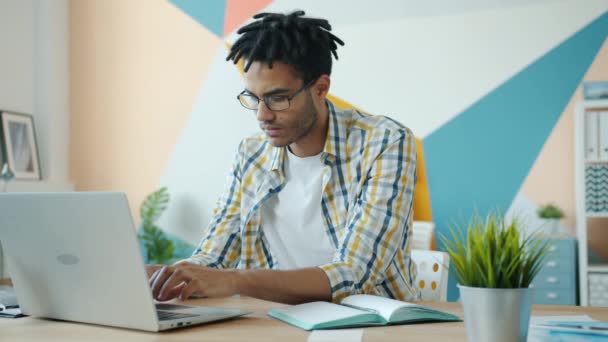 Homme afro-américain fatigué de travailler avec un ordinateur portable au bureau souffrant de maux de tête — Video