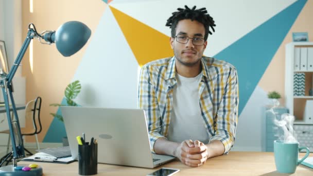 オフィスの部屋でデスクでハンサムなアフリカ系アメリカ人ビジネスマンのシネマグラフの肖像 — ストック動画
