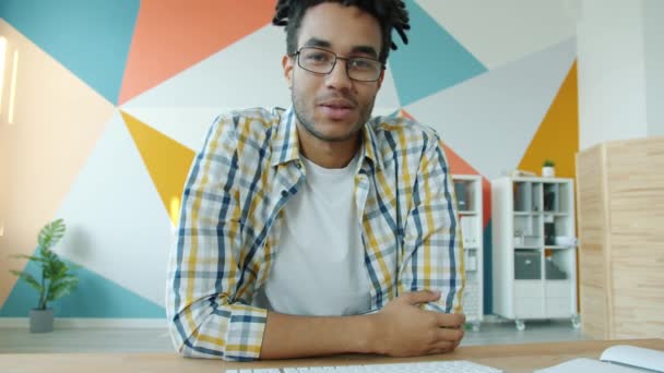 Afroamerykański biznesmen wykonujący rozmowy wideo przez Internet za pomocą laptopa patrząc w kamerę — Wideo stockowe