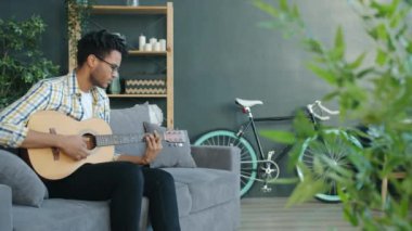 Evde boş zamanlarında gitar çalıp şarkı söyleyen yaratıcı Afro-Amerikalı bir adam.