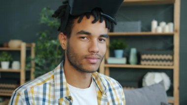 Evdeki Afro-Amerikalı adamın portresi. Kameraya bakıyor. Sonra da sanal gerçeklik gözlüğü takıyor.