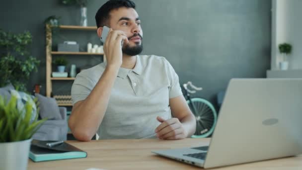 Midden-Oosten jongeman spreekt op mobiele telefoon thuis het delen van nieuws — Stockvideo