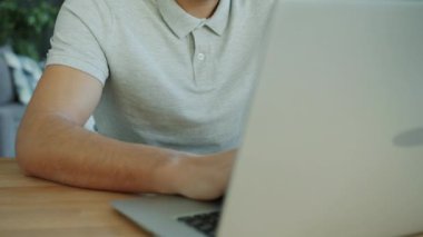 Dairede dizüstü bilgisayarla çalışan yakışıklı bir Arap 'ın eğik portresi.