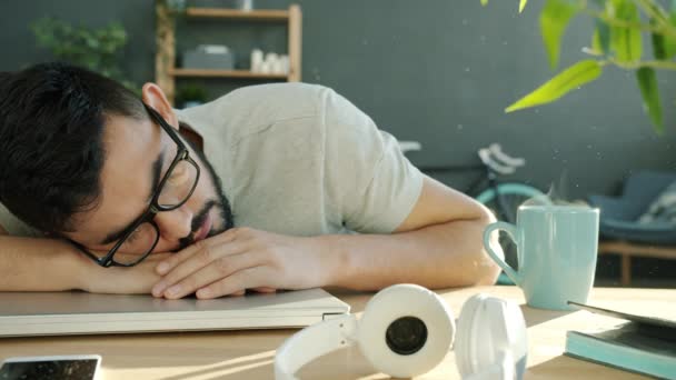 Fatigué gars sieste sur la table à la maison après le travail indépendant avec ordinateur portable — Video