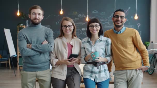 Portrait de jeunes gens joyeux collègues debout dans un bureau créatif partagé souriant — Video