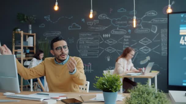 Arabisk man kontorsarbetare firar goda nyheter höja vapen medan laget klappar händerna — Stockvideo