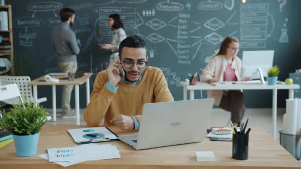 Ralentissement de l'entrepreneur du Moyen-Orient parlant sur téléphone mobile dans un bureau à aire ouverte — Video