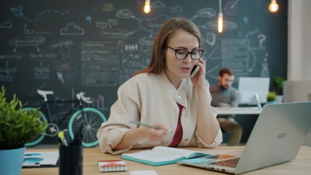 Jovem alegre recebendo boas notícias no telefone celular expressando felicidade no escritório compartilhado — Vídeo de Stock