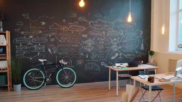 Zoom arrière du bureau créatif moderne avec mur de tableau noir et bureaux sans personne — Video