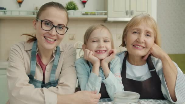 Portret van een vrolijke grootmoeder, moeder en dochter glimlachend in de moderne keuken — Stockvideo