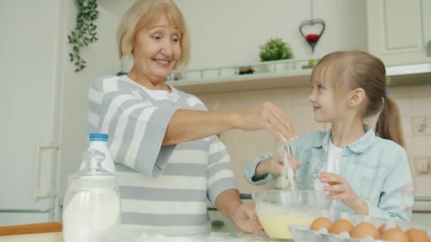 Barn och mormor matlagning bakverk blanda deg, gammal dam lägga mjöl prata med barn — Stockvideo
