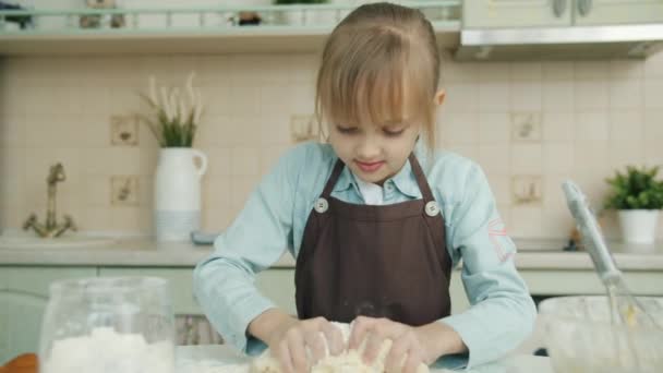 Cámara lenta de adorable niña mezclando masa pastelería en la cocina en casa — Vídeos de Stock