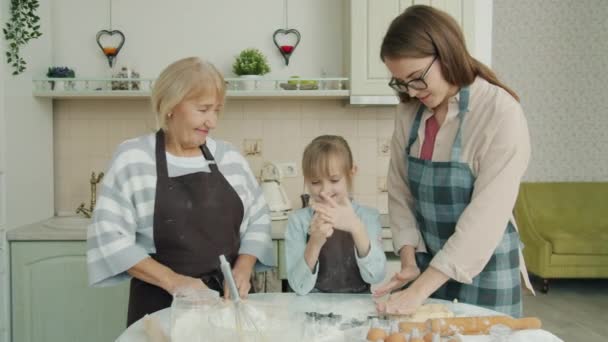 Petite fille, mère et grand-mère cuisiner dans la cuisine et parler en profitant du temps ensemble — Video