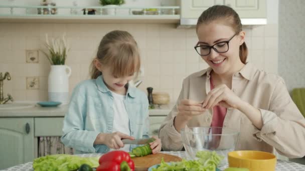 Hjälpsam dotter göra sallad medan mor röra hennes hår uttrycker kärlek hemma — Stockvideo