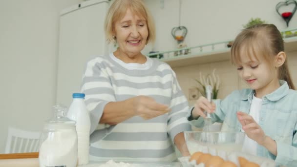 Glad familj litet barn och kärleksfull mormor matlagning i kök i lägenhet blanda deg — Stockvideo